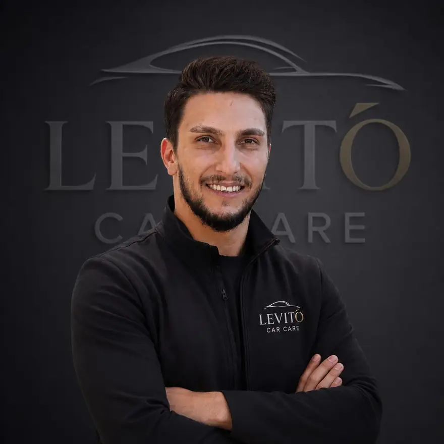 Yunus Karaca, Inhaber von LEVITÓ Car Care in München, vor dem LEVITÓ-Logo